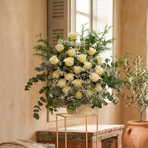 Elegante centro rosas boda en tono blanco con eucalipto sobre pie dorado